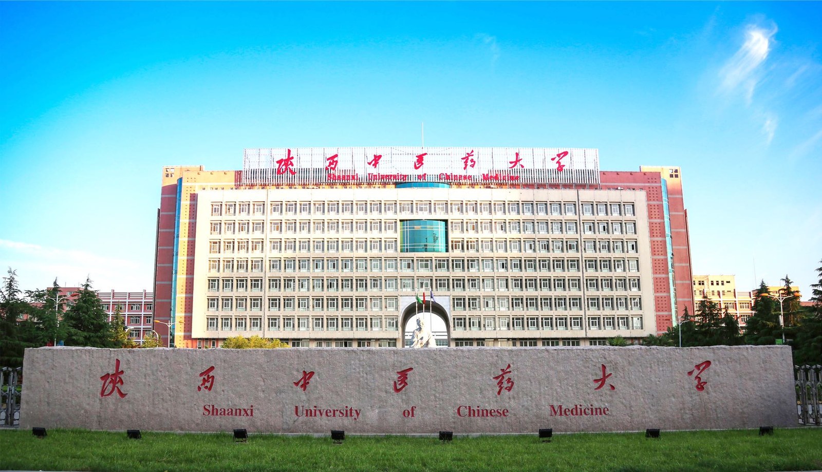 蓝天映衬下的陕西中医药大学教学楼与校名石